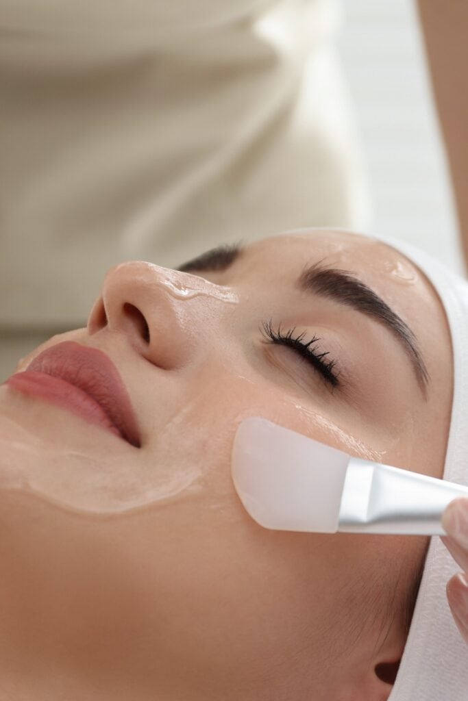 Young woman during face peeling procedure in salon